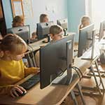 A row of students working on computers in a classroom.